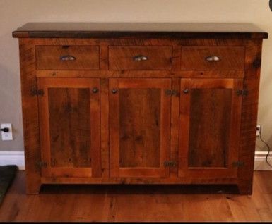 A wooden cabinet with three drawers and three doors
