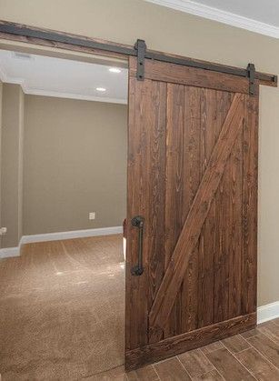 A wooden sliding barn door is open to a room.
