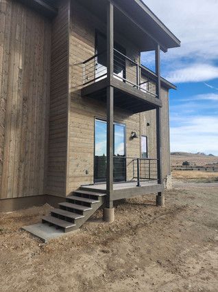 A house with a balcony and stairs on the side of it.