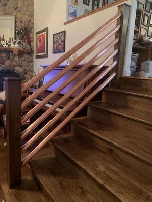 A wooden staircase with a wooden railing in a living room.