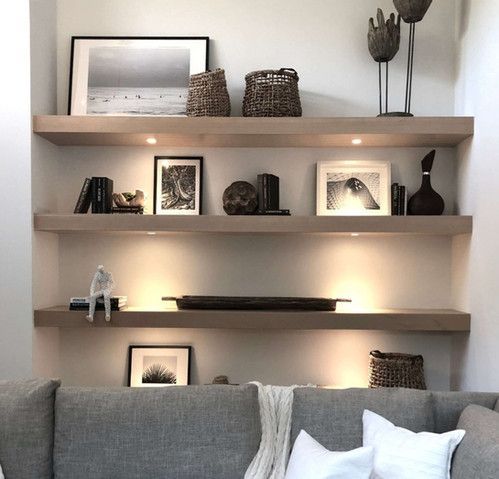 A living room with a couch and shelves with pictures on them