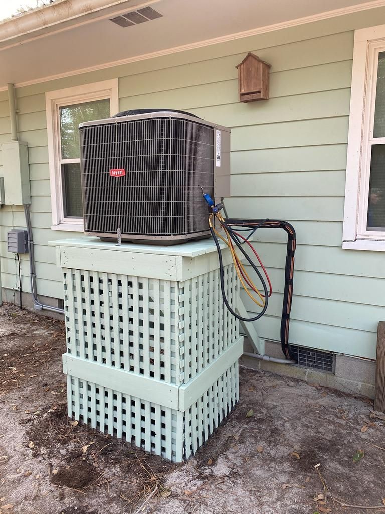 An air conditioner is sitting on the side of a house.