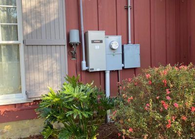 A house with a electrical box on the side of it.