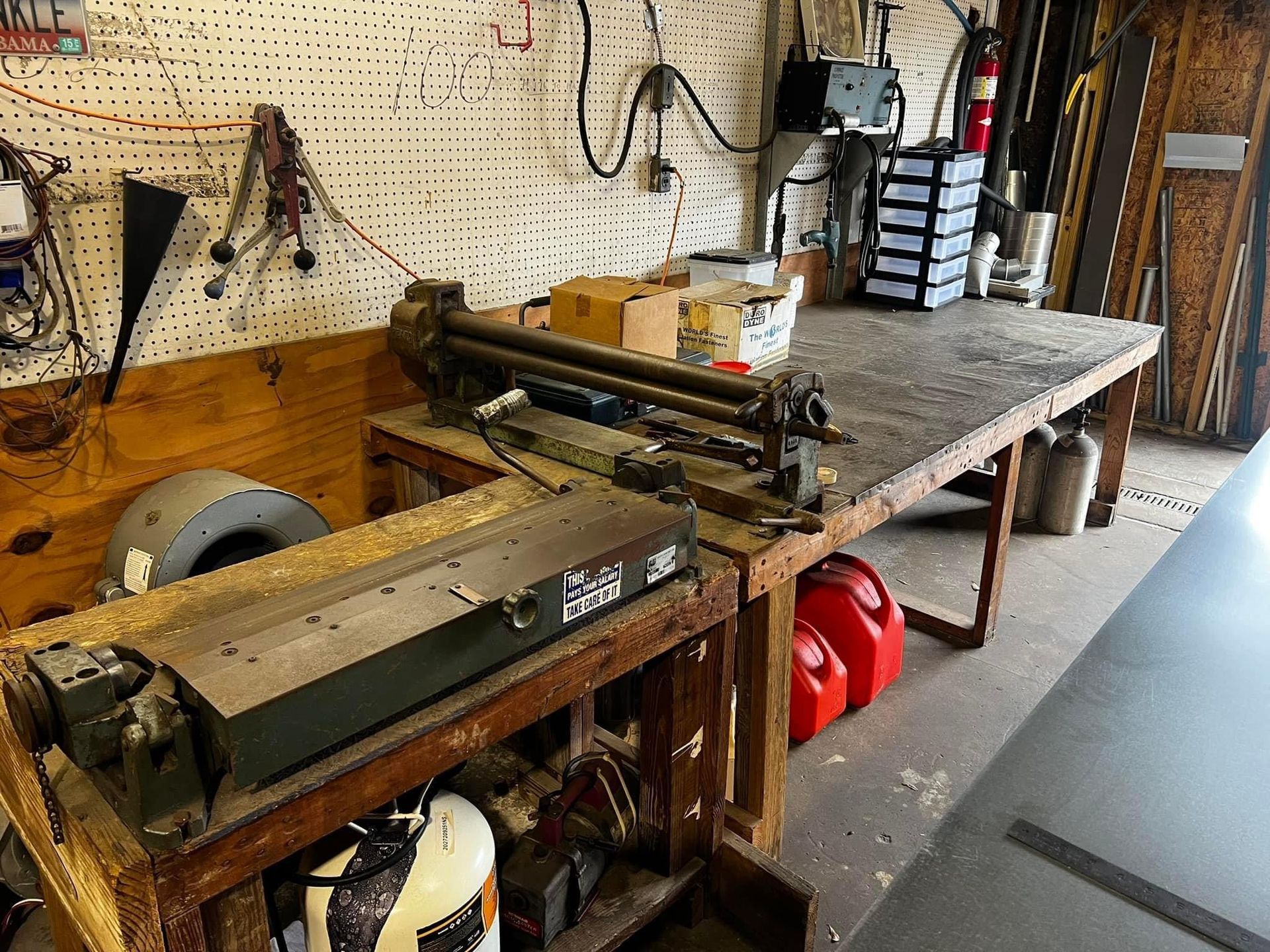 A wooden workbench with a machine on it in a garage.