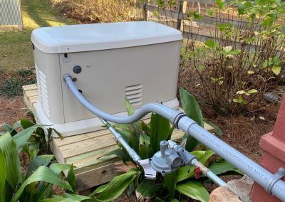 A generator with a hose attached to it is sitting on top of a wooden platform.