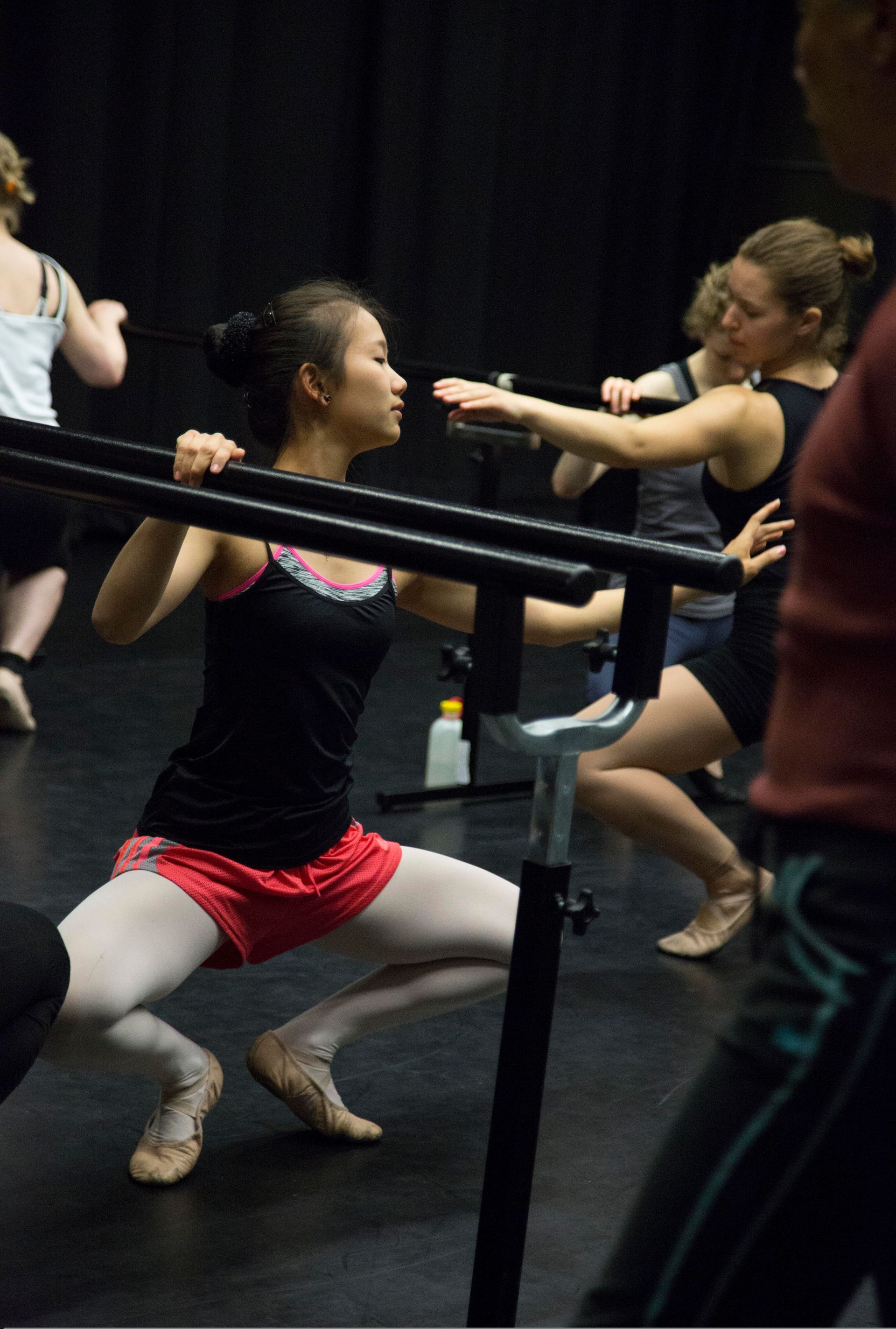 Woman practicing ballet technique at the barre in ballet class