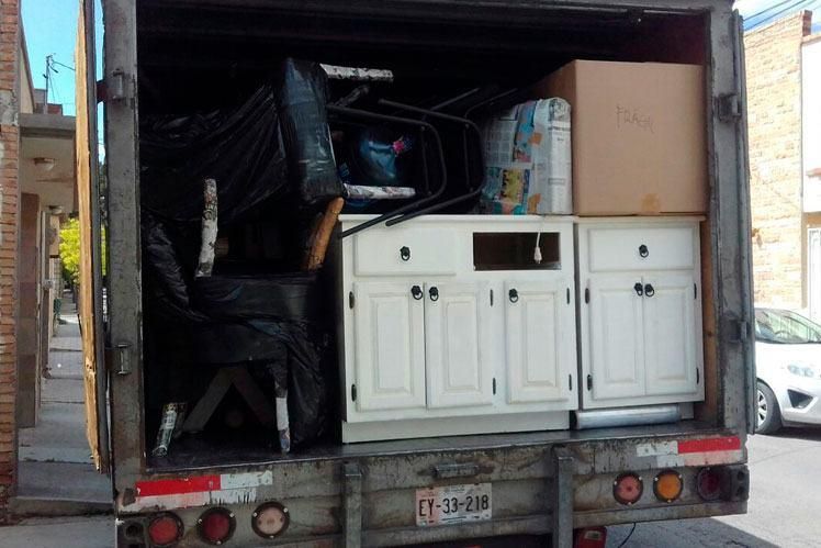 Un camión de mudanzas está lleno de muebles y cajas.