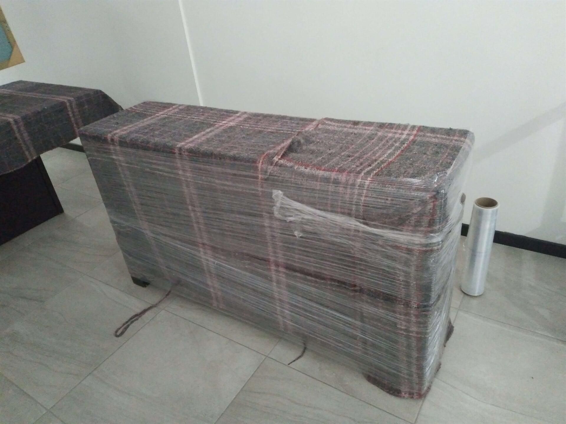 Una cómoda está envuelta en film plástico en una habitación.
