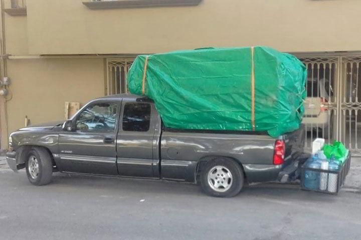 Un camión con una lona verde encima