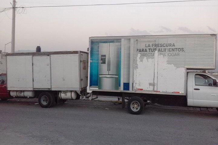 Un camión con un refrigerador en la parte trasera.