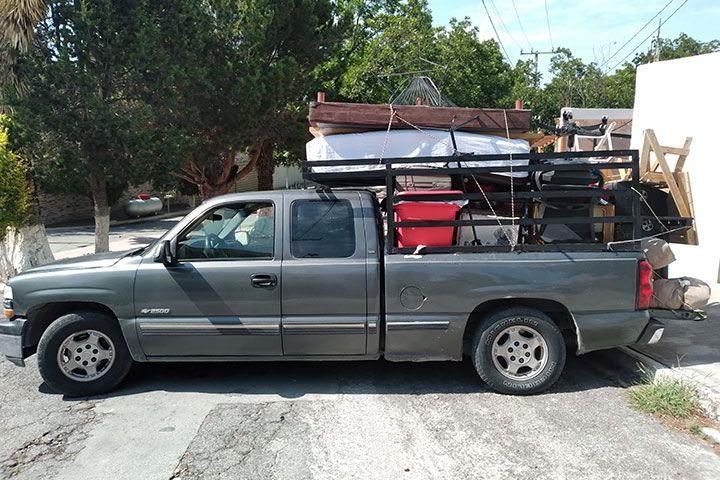 Un camión gris está estacionado al costado de la carretera.