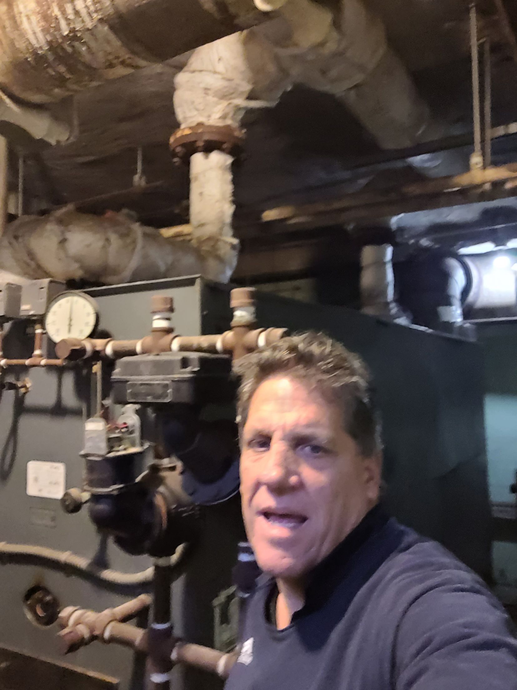 man in basement with HVAC unit