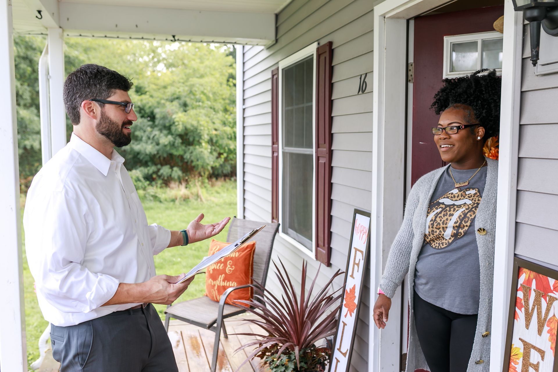 Geoff Luxenberg is talking to a neighbor on the porch of a house.