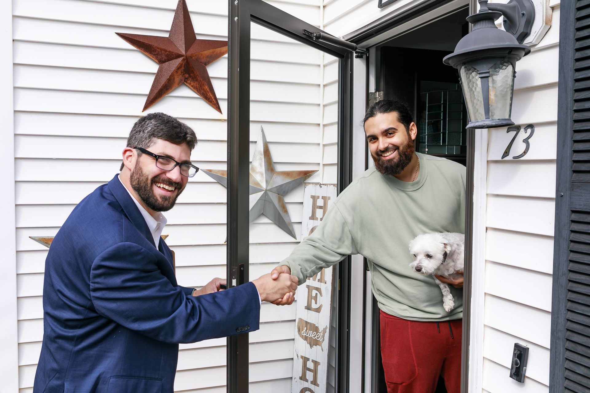 Geoff Luxenberg shaking hands in front of a house.