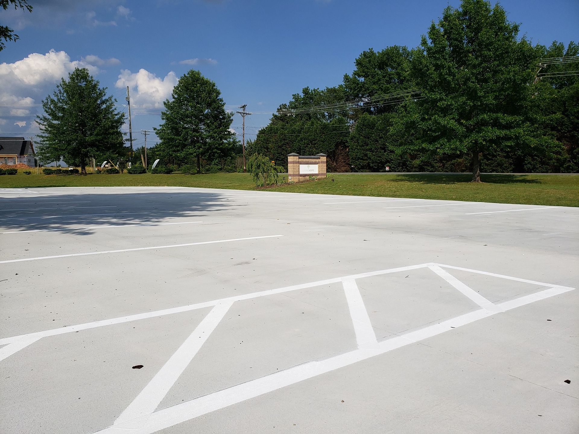 An empty parking lot with trees in the background