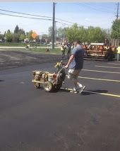 A man is pushing a cart with buckets on it in a parking lot.
