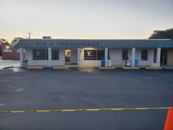 A restaurant is sitting in the middle of a parking lot.