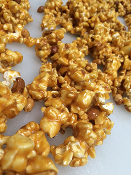 A close up of a pile of caramel popcorn on a table.