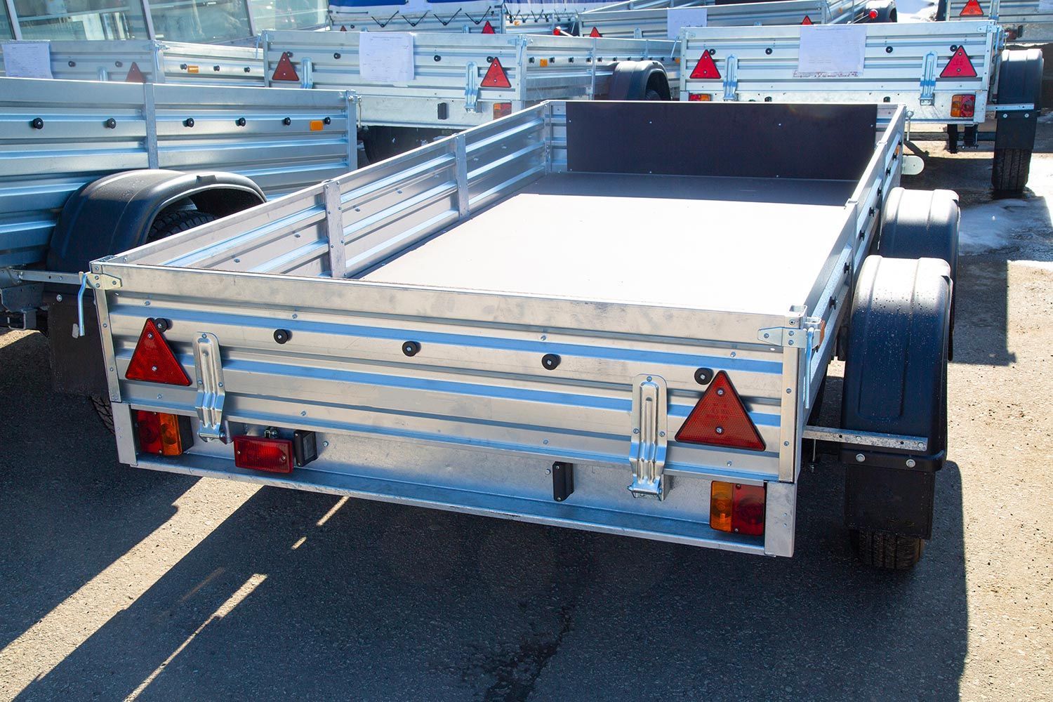 Silver utility trailers on a sunny day