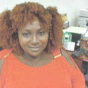 A woman with red hair is wearing an orange shirt.