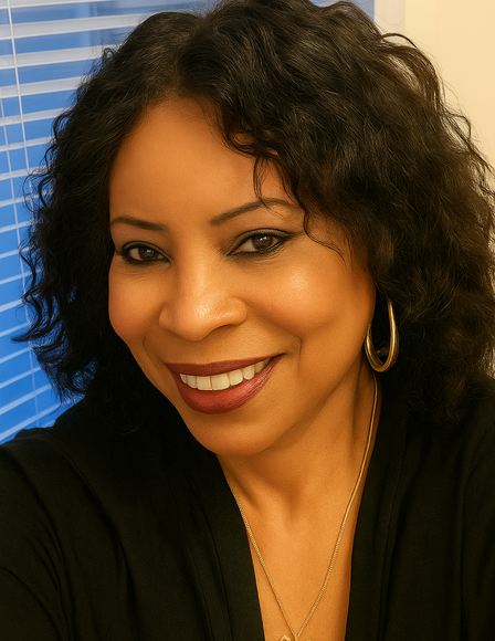 A woman with curly hair and hoop earrings is smiling for the camera.