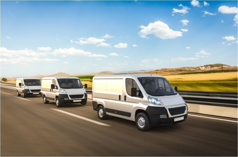 three courier vans driving along an empty road
