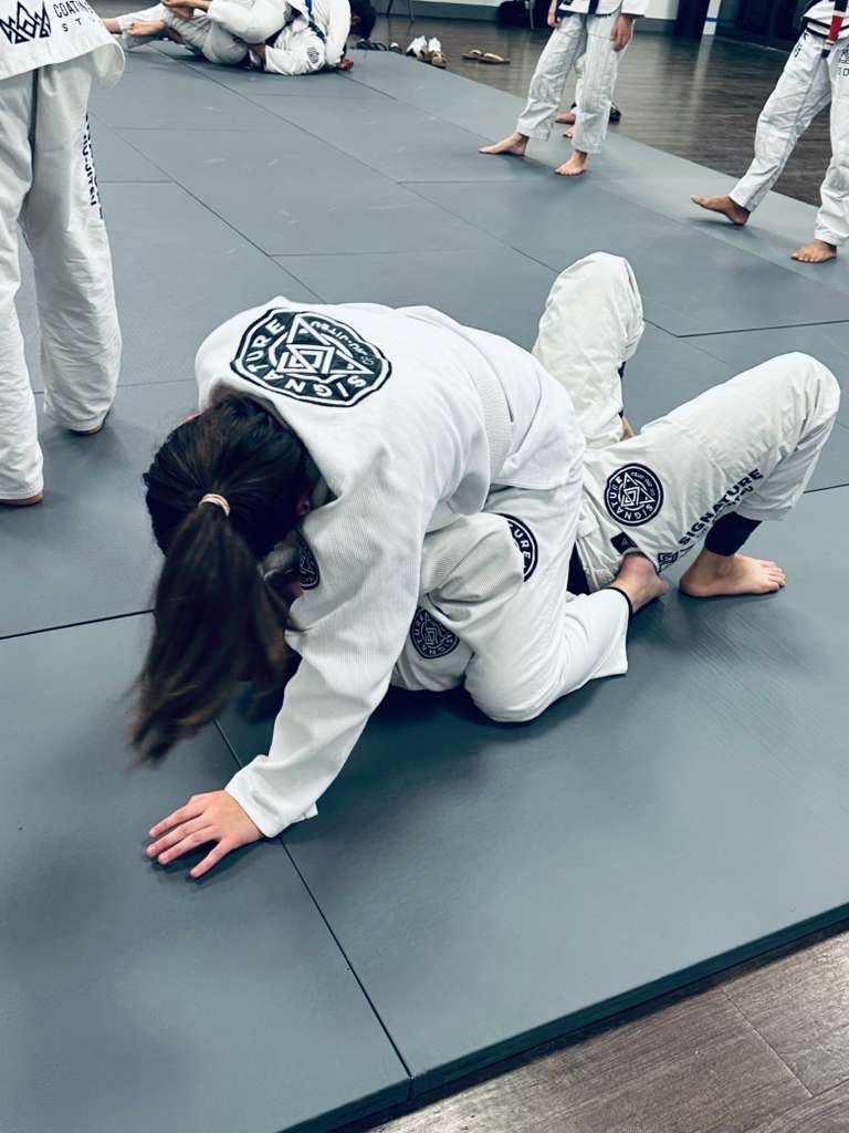 Students drilling Brazilian Jiu-Jitsu techniques at Signature of Jiu-Jitsu in Belmont, CA to build resilience.