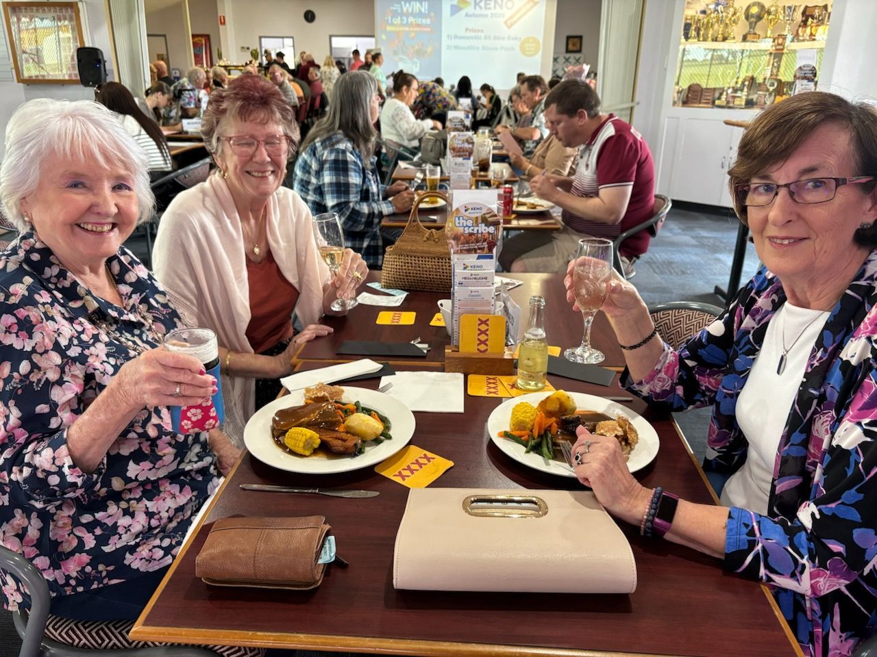 A Group Of People Are Sitting At A Table With Plates Of Food — Maryborough Cricket Club In Maryborough, QLD