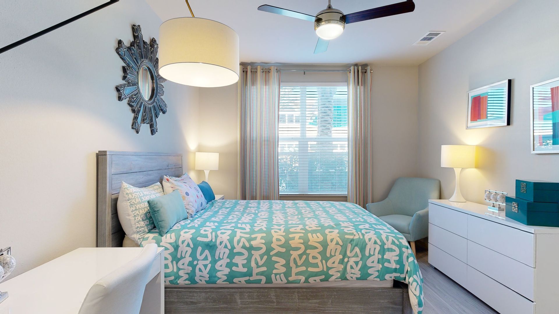 A bedroom with a large bed and a ceiling fan.