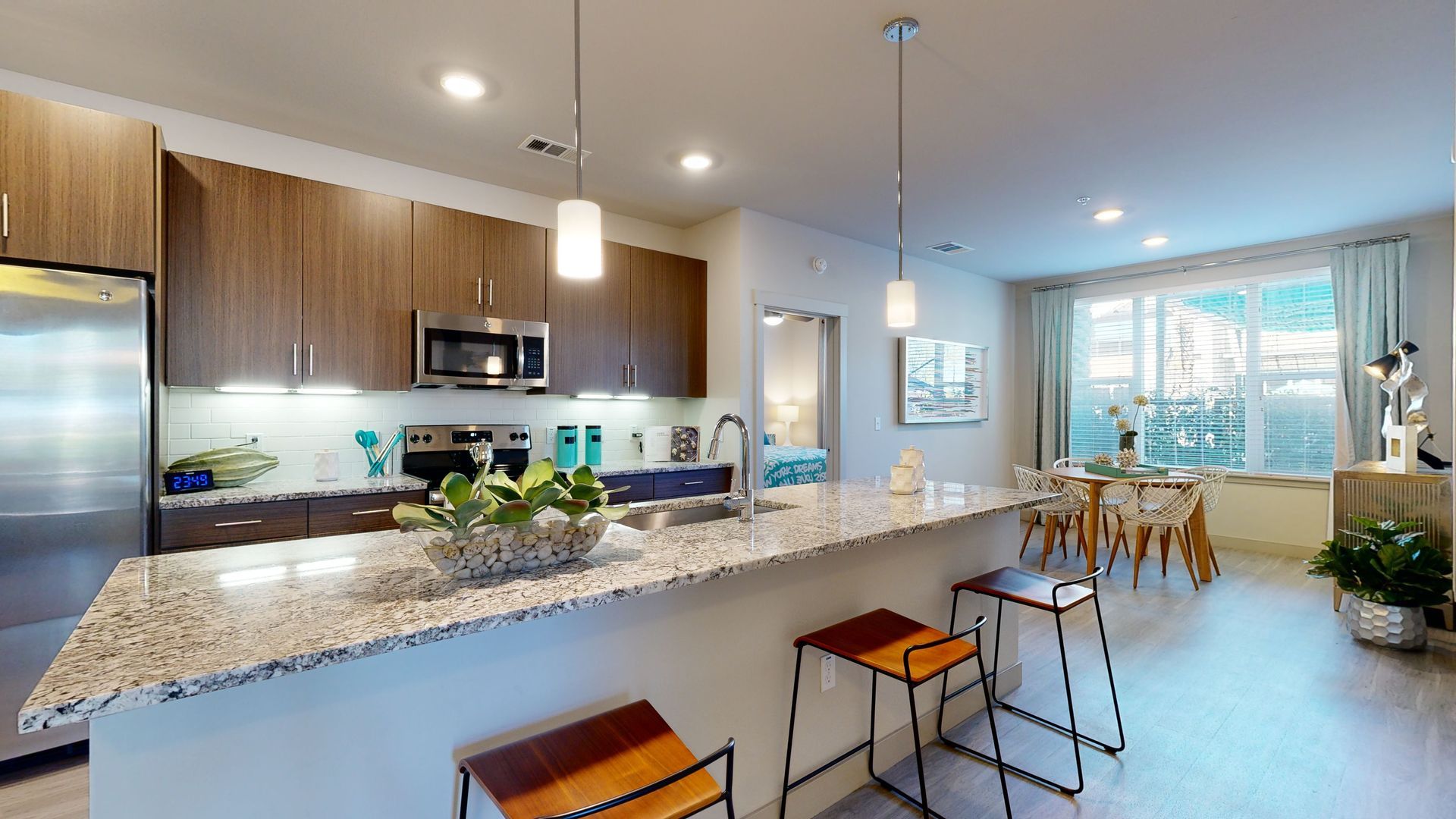 A 3d model of a kitchen with a large island and stools.