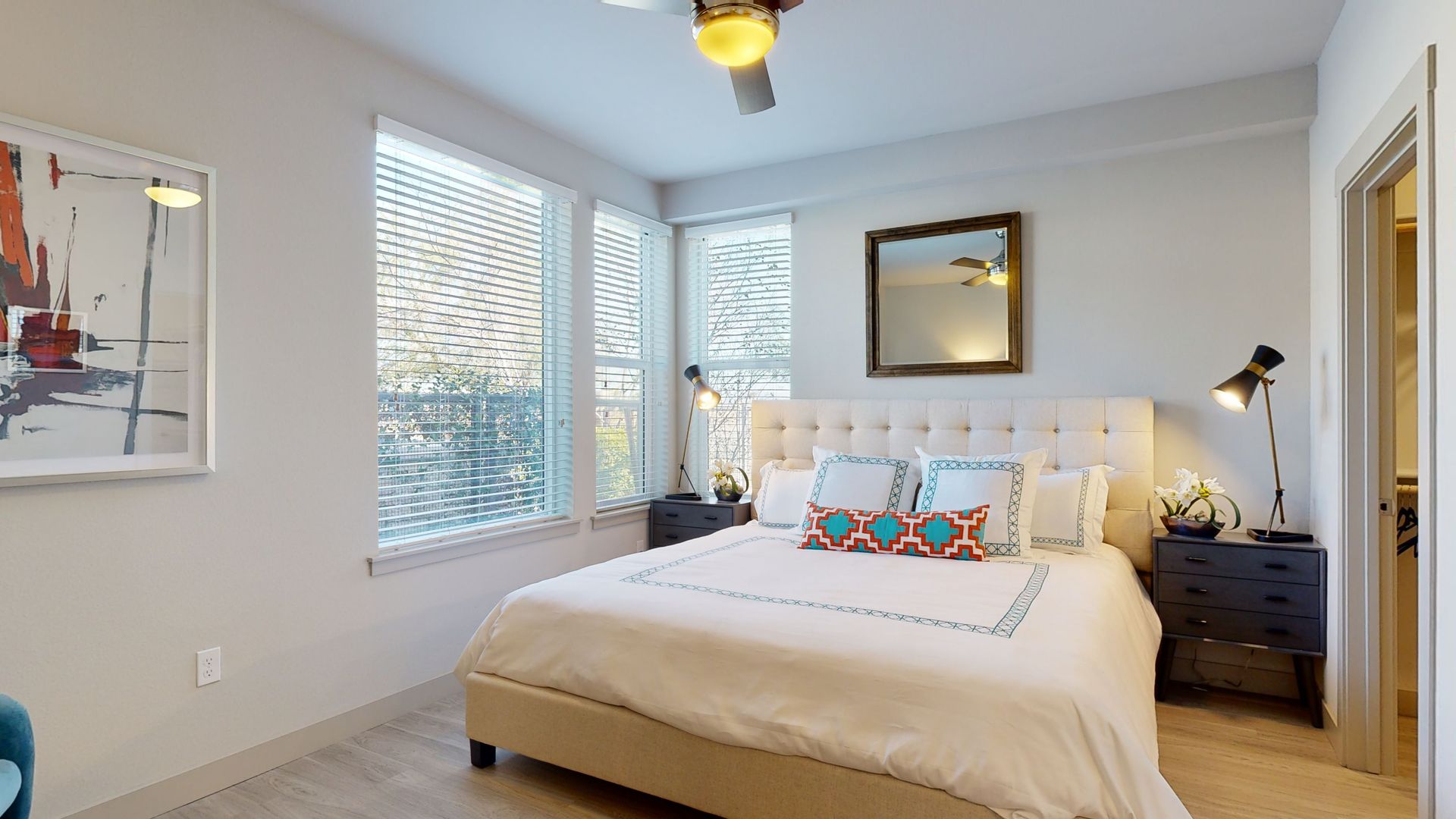 A bedroom with a large bed and a ceiling fan.