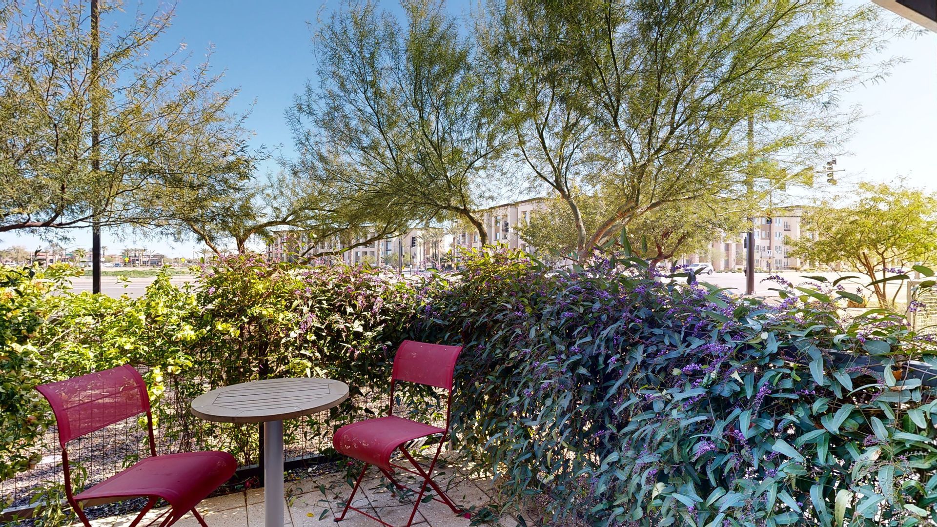 There is a table and chairs in the middle of a garden.