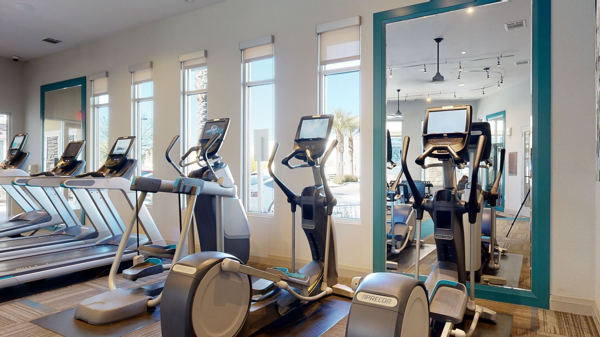 A gym with a lot of exercise equipment and a large mirror.