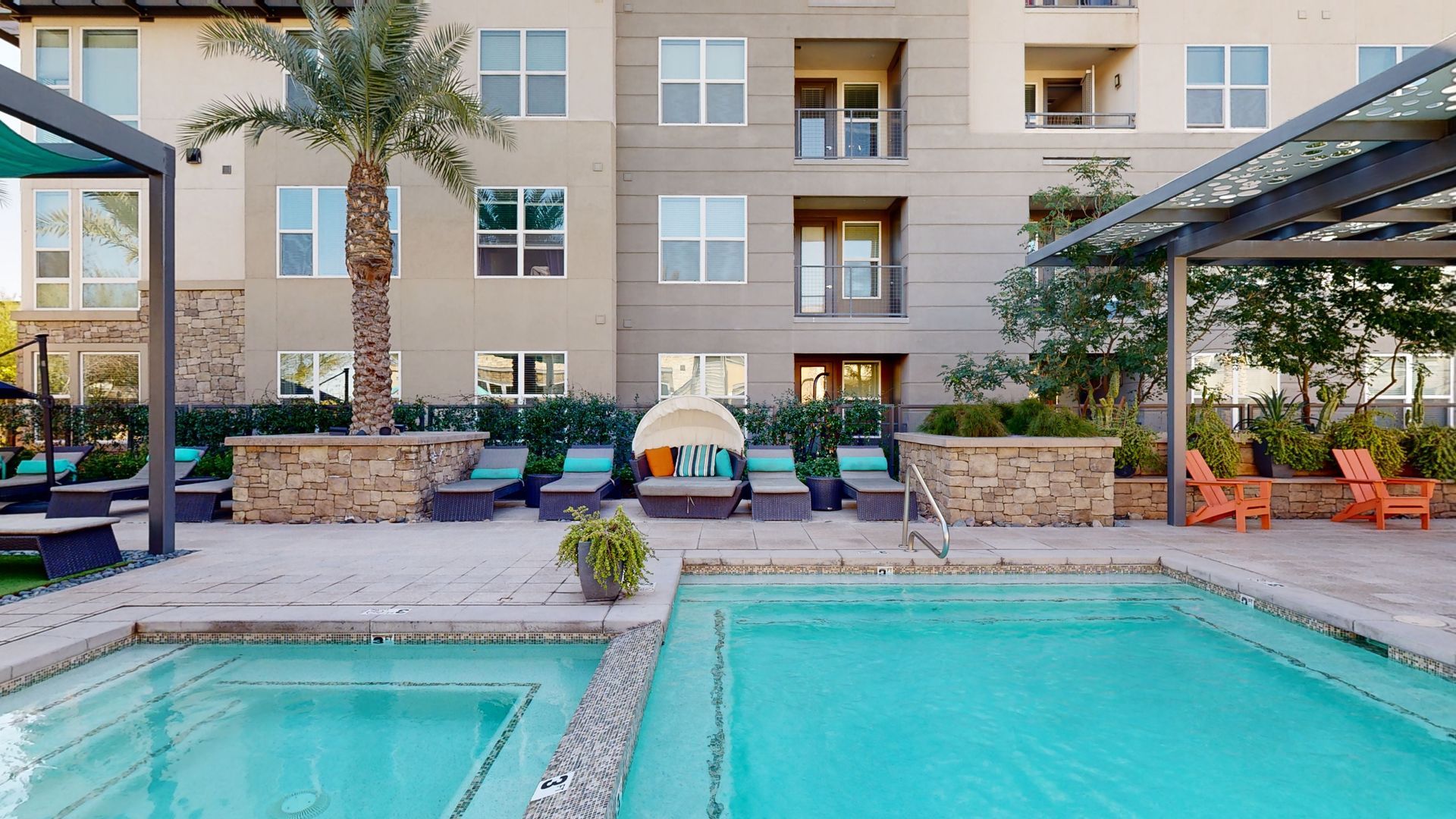There is a large swimming pool in front of a building.