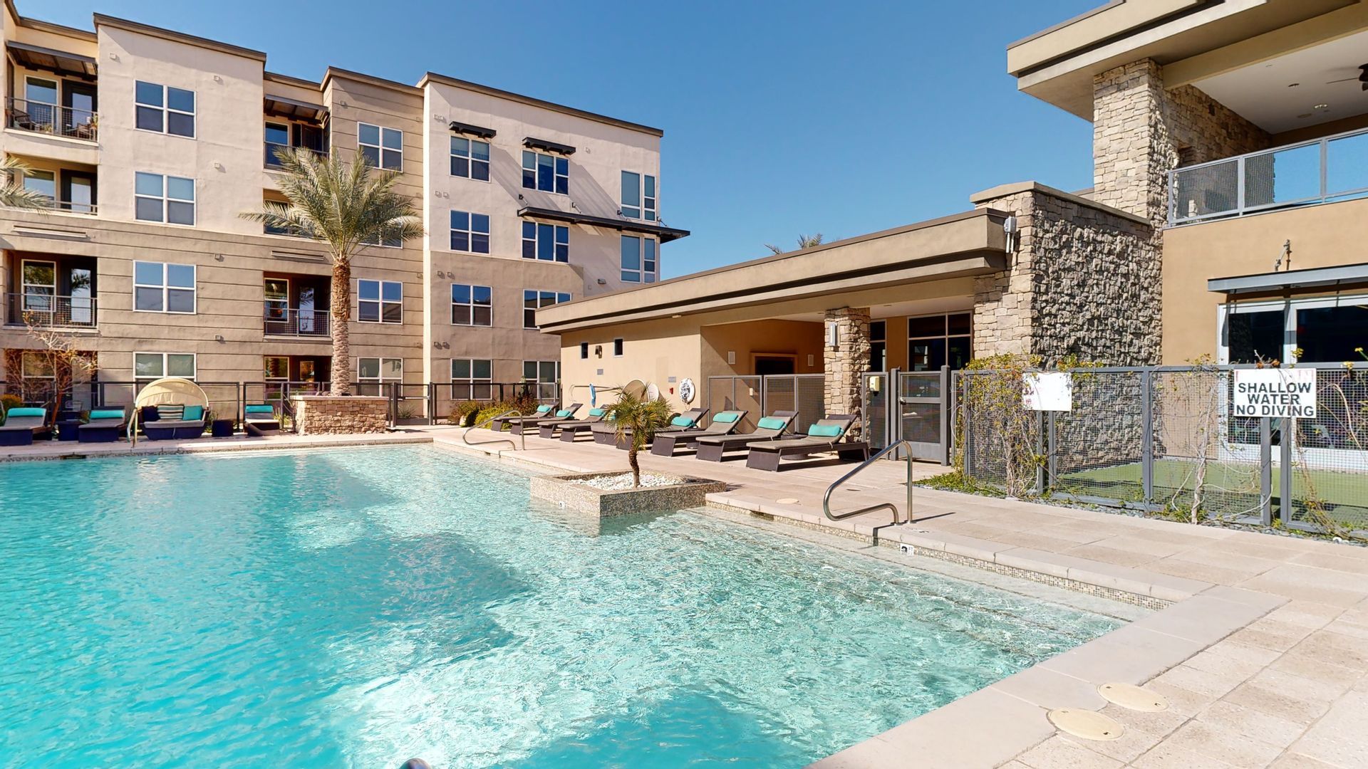 There is a large swimming pool in front of a building.