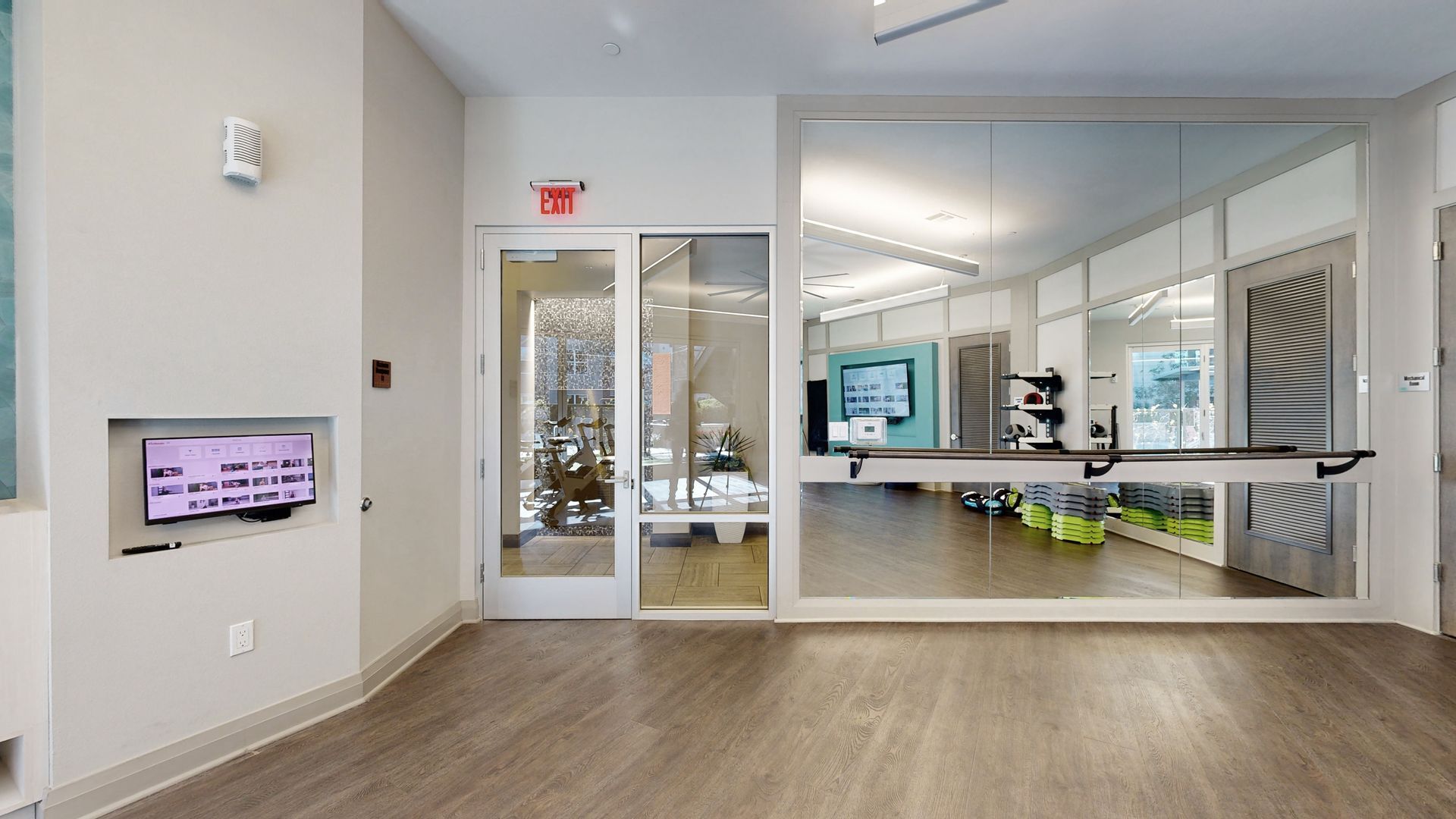 A large room with a glass door and a television on the wall.