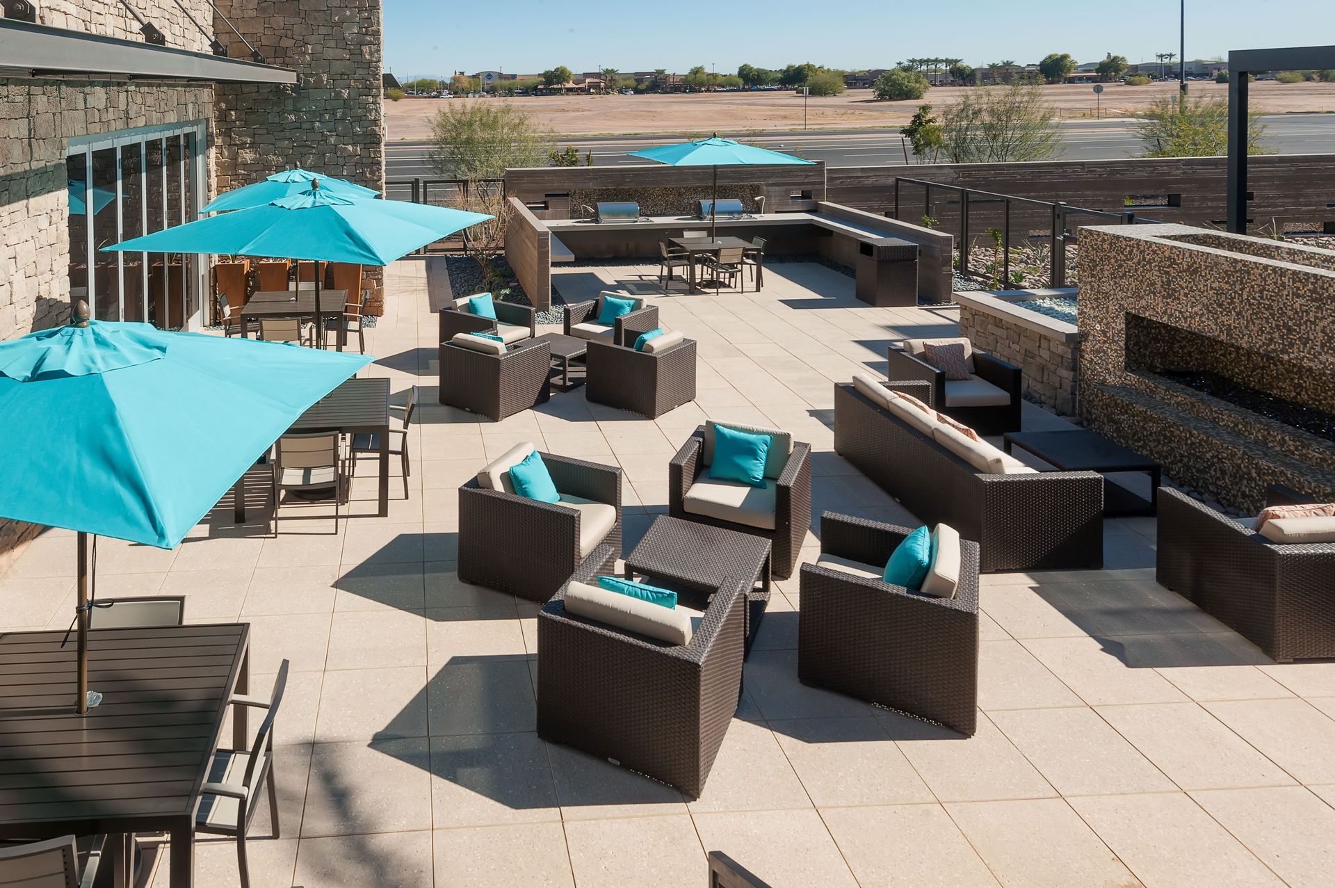 A patio with a lot of furniture and umbrellas