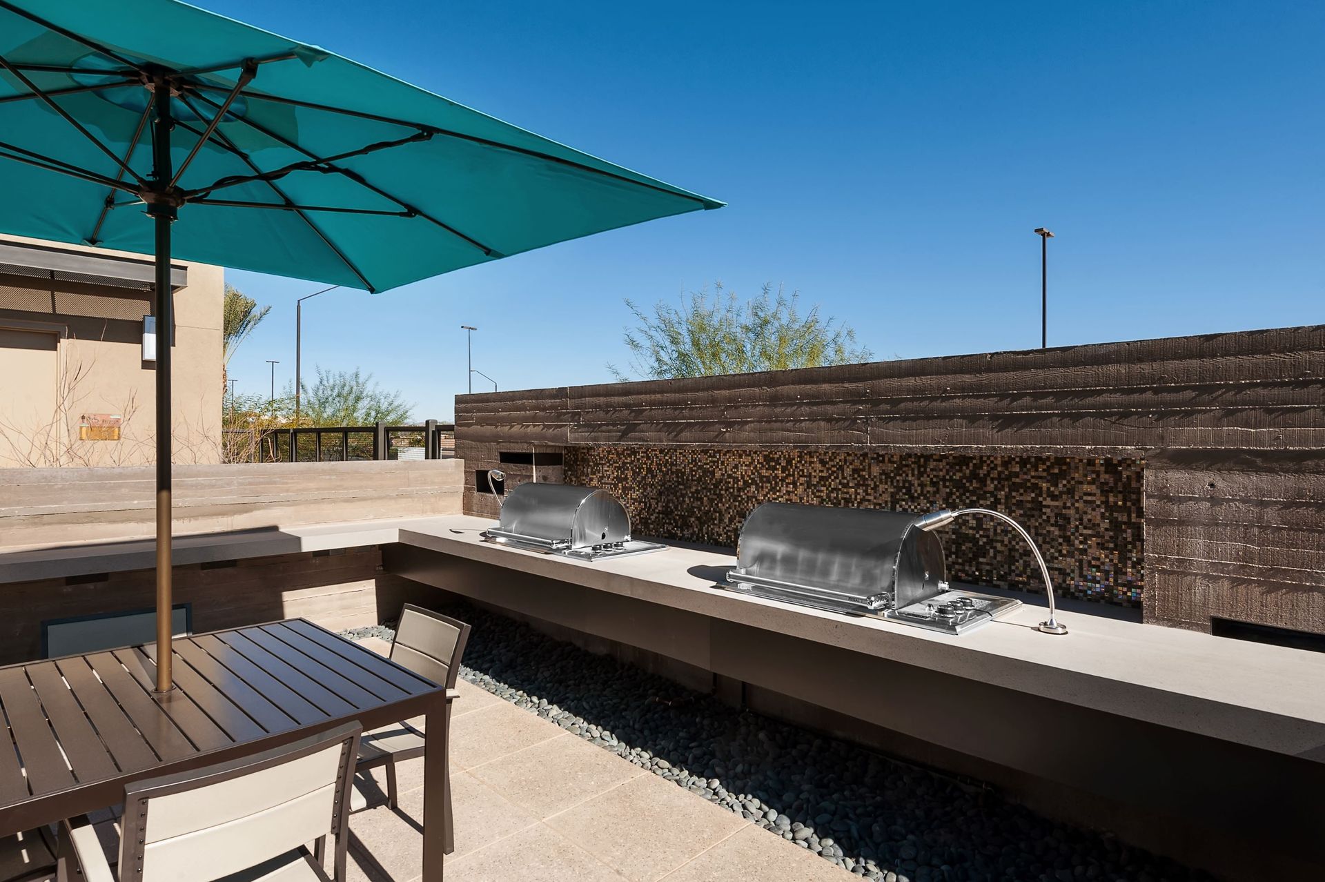 A patio with a table and chairs under an umbrella