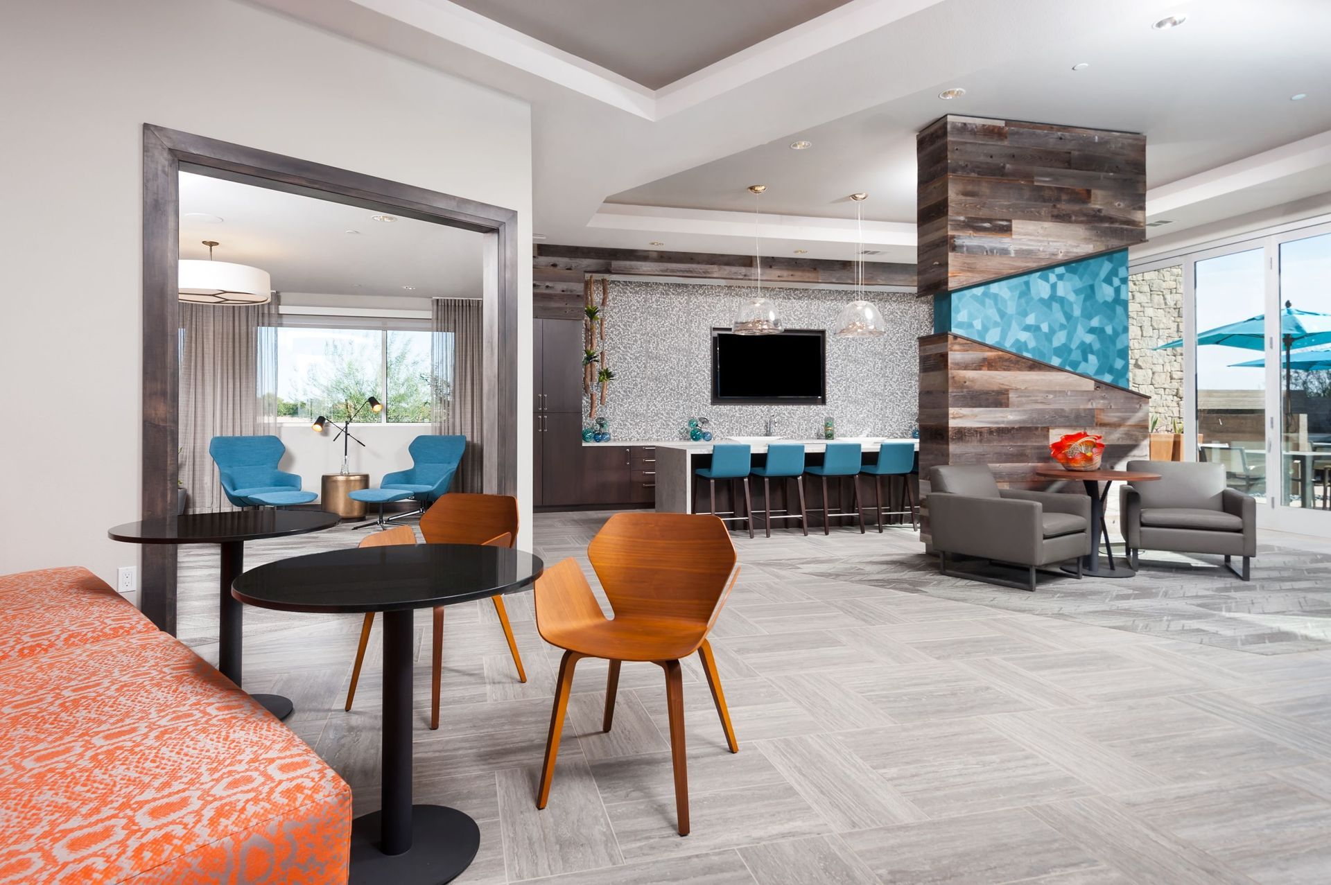 A living room with tables and chairs and a flat screen tv.