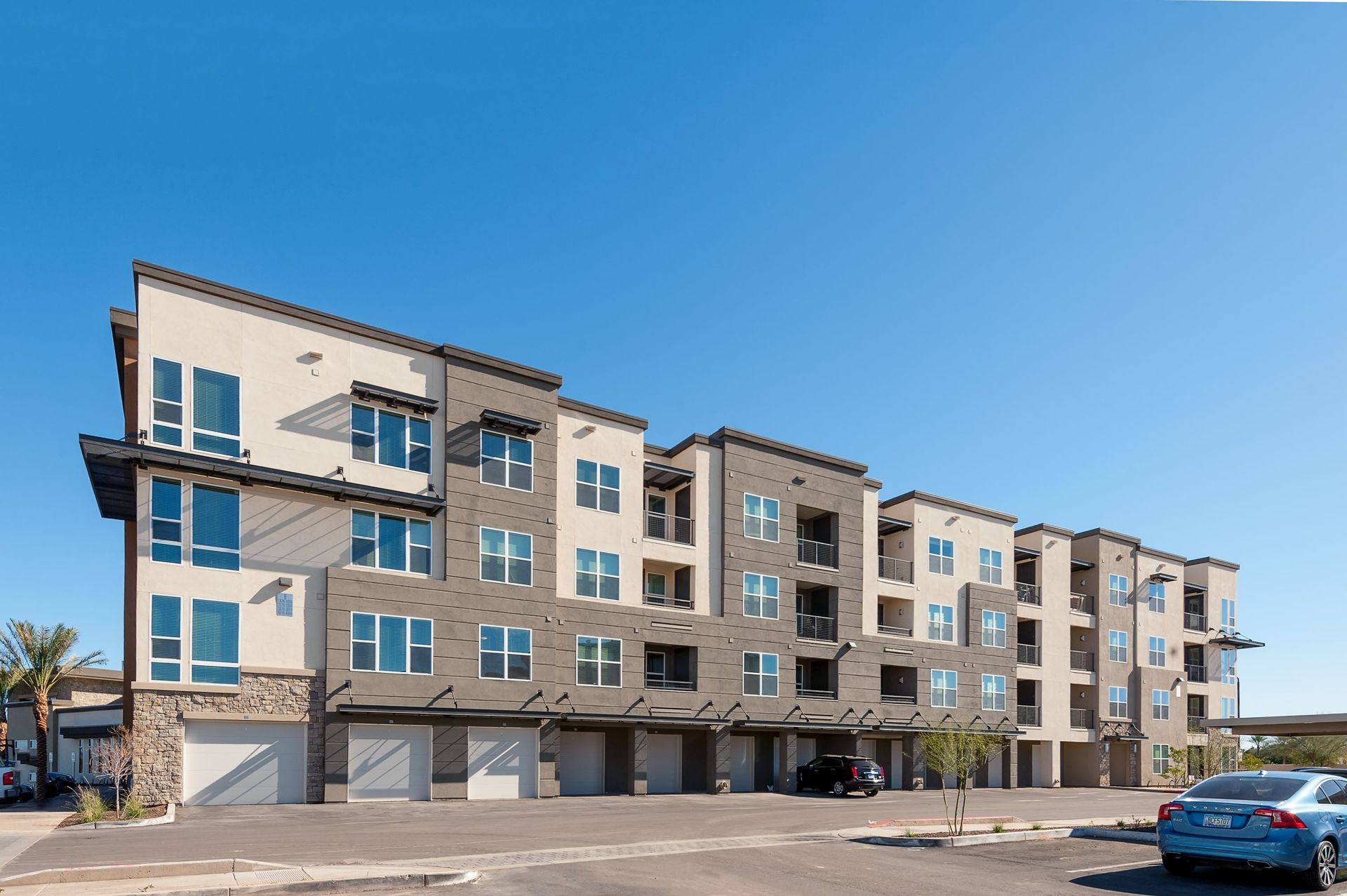 A large apartment building with cars parked in front of it