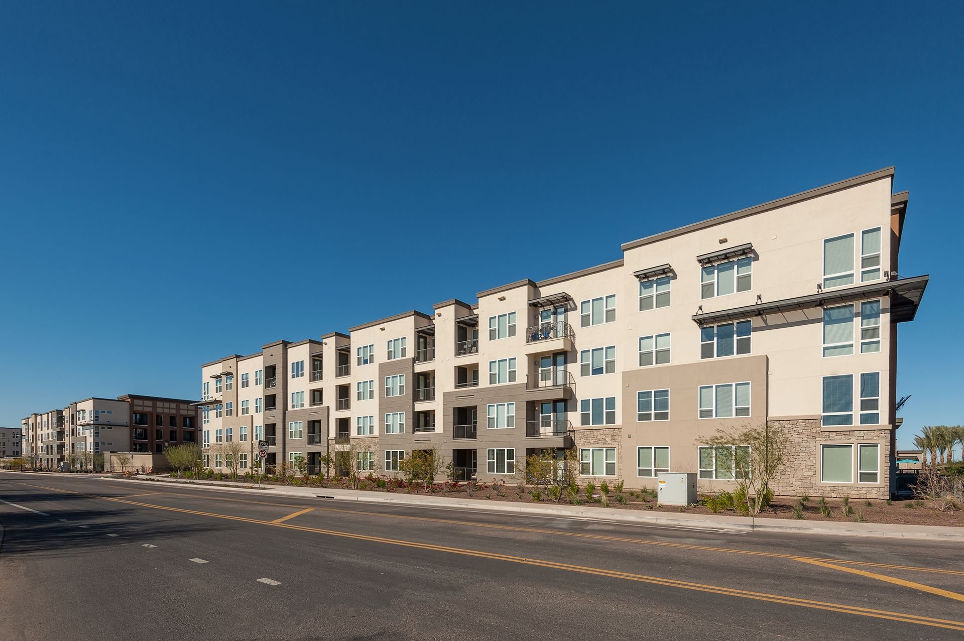 A large apartment building with a blue sky in the background