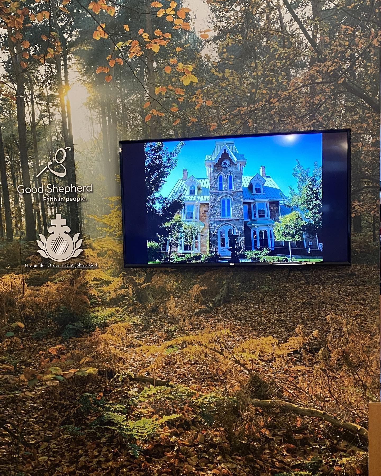a large flat screen tv shows a house in the woods