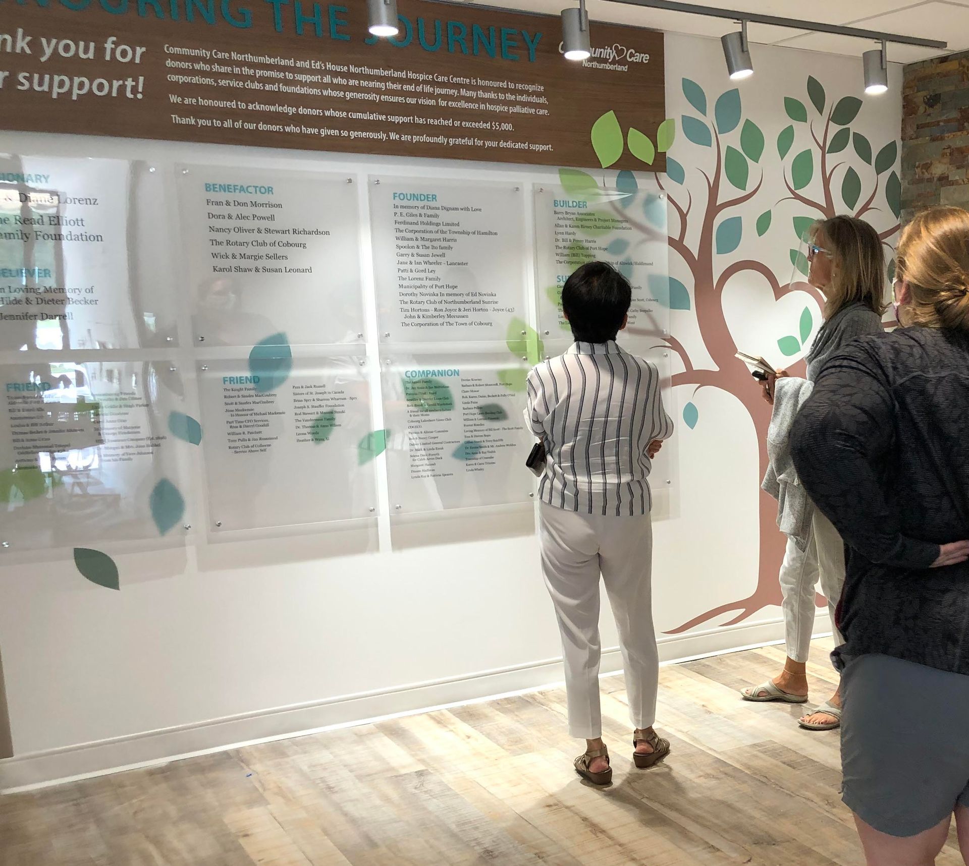 a man is touching a screen in front of a sign that says ' tennial college '