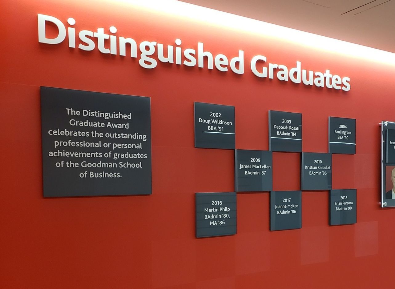 a red wall with the words distinguished graduates on it