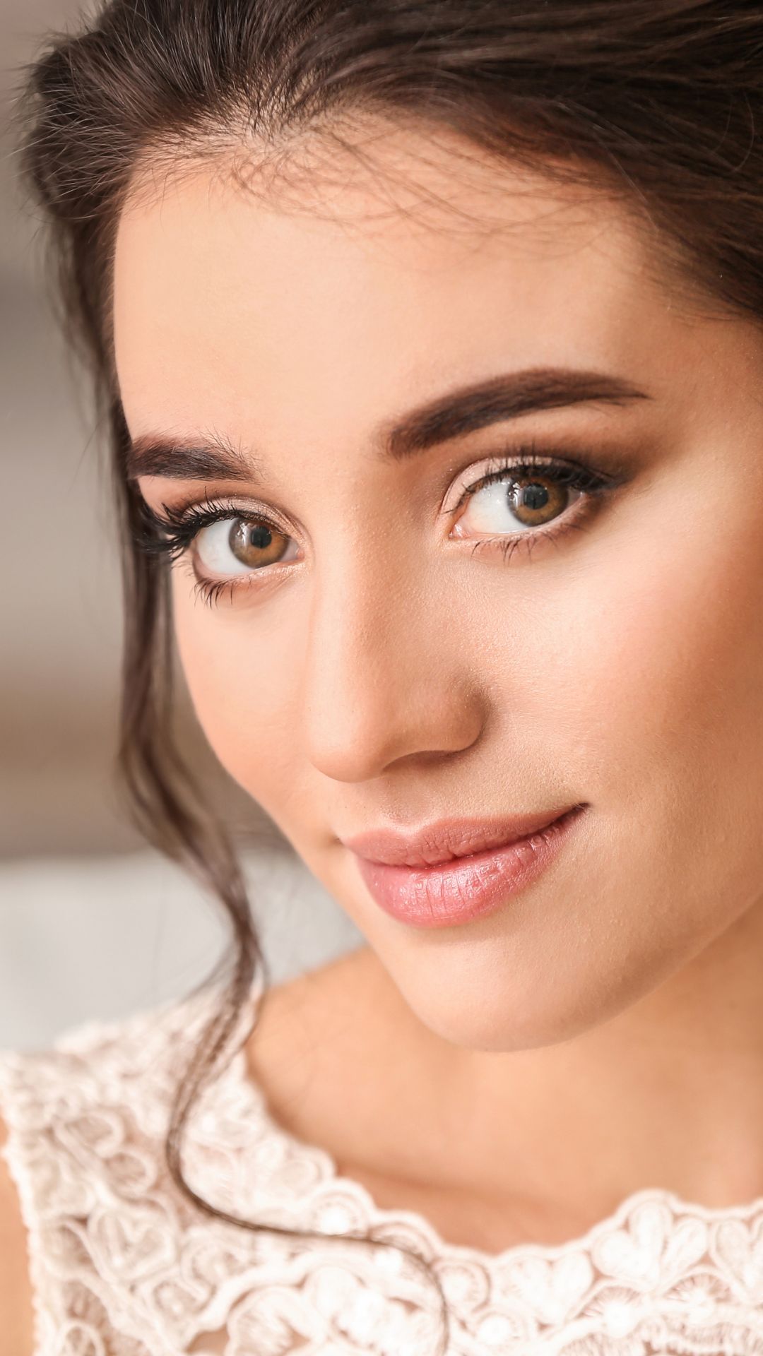 A close up of a woman 's face wearing a white dress.