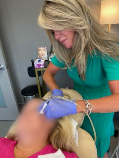 An elderly woman is getting a facial treatment at a beauty salon.