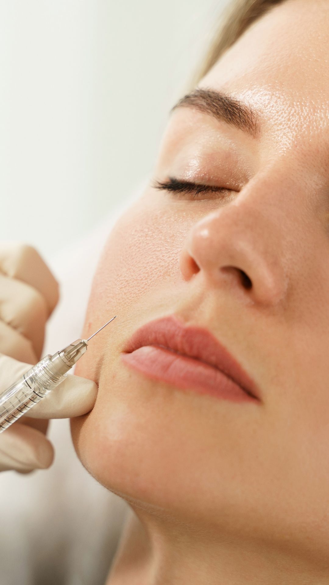 A woman is getting a botox injection in her face.