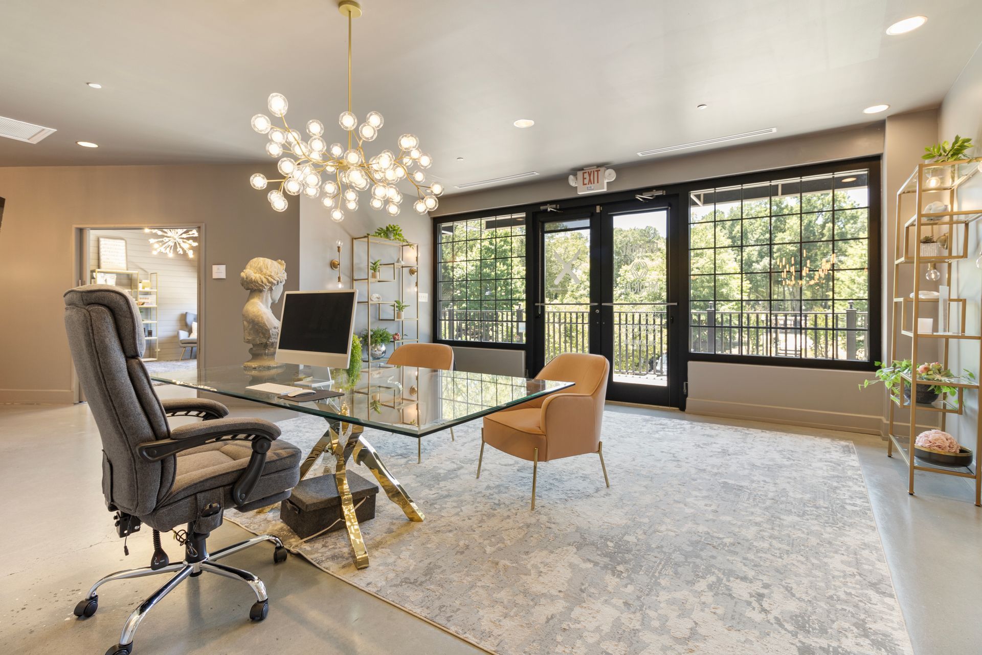 A home office with a desk and chairs and a large window. Office Tour