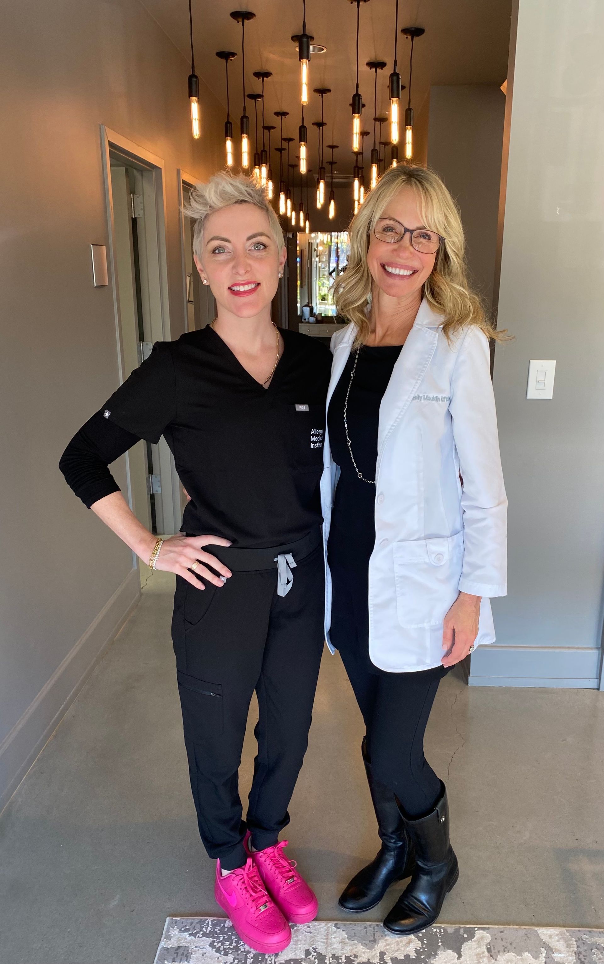 Two women are standing next to each other in a hallway.