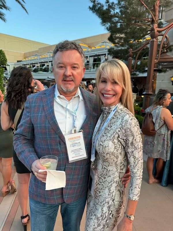 A man and a woman are posing for a picture at a party.